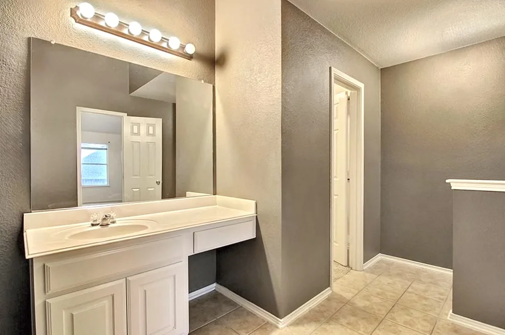 Finished bathroom with gray walls and white trim