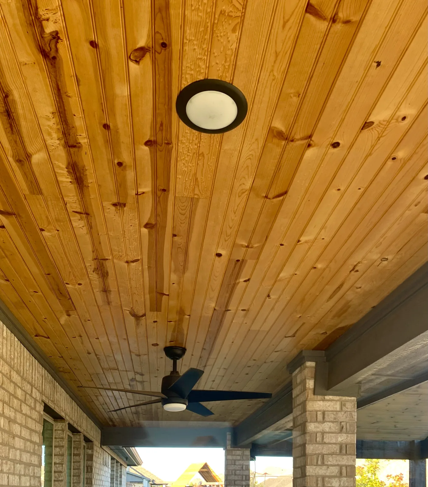 Finished wood-plank porch ceiling with recessed lighting